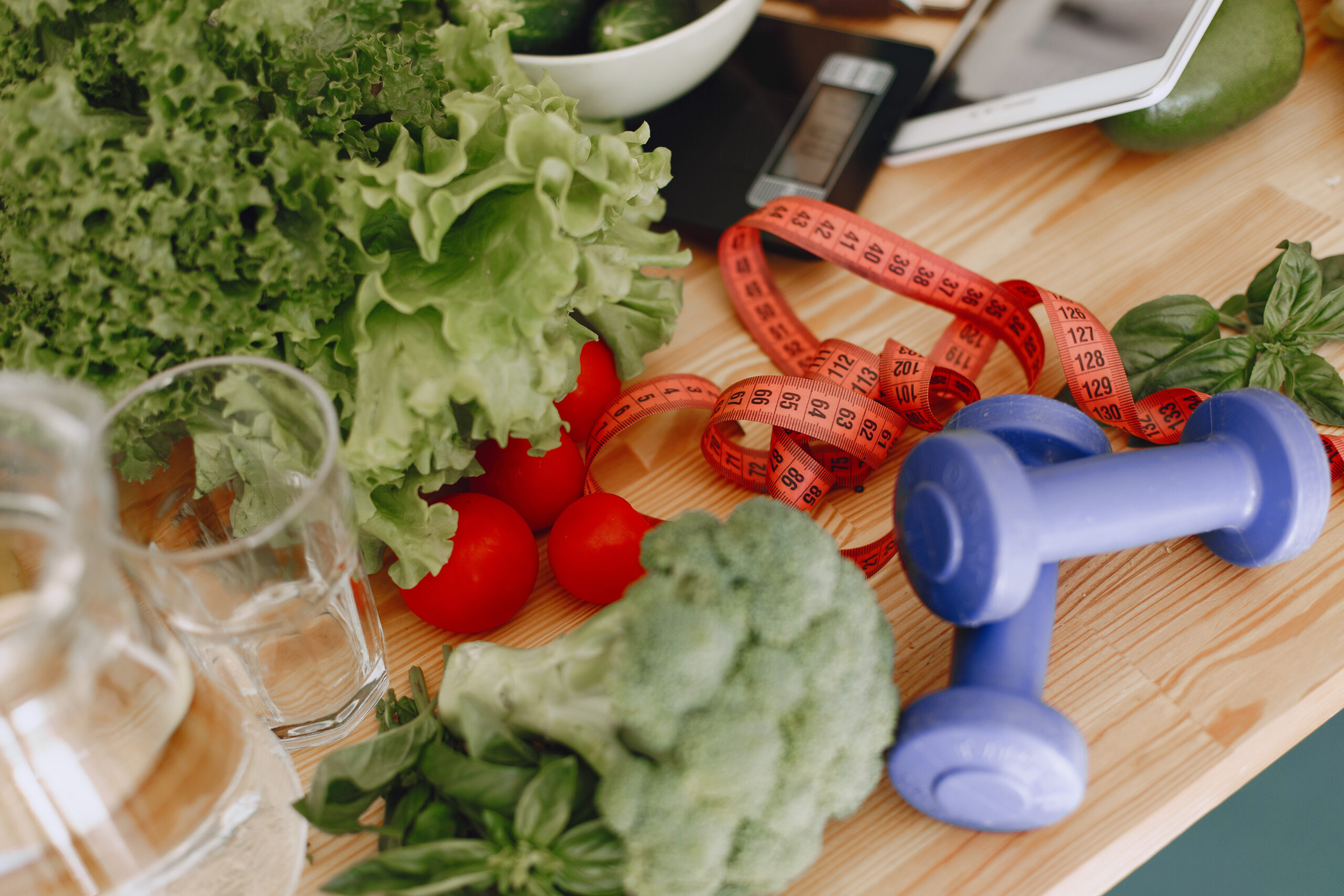 scales tape measure dumbbells and vegetables